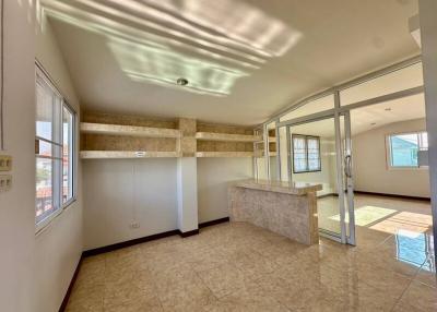 Spacious and well-lit living area with tiled flooring and large windows