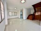 Spacious living area with staircase and abundant natural light