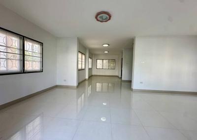 Spacious empty interior of a bright building with large windows and tiled flooring