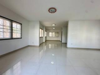 Spacious empty interior of a bright building with large windows and tiled flooring