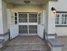 Elegant front entrance of a residential property with decorative door and brick paving