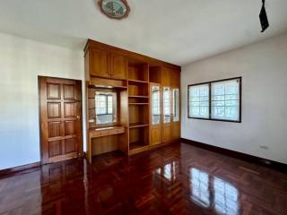 Spacious living room with wooden floors and built-in cabinets