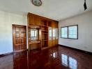 Spacious living room with wooden floors and built-in cabinets