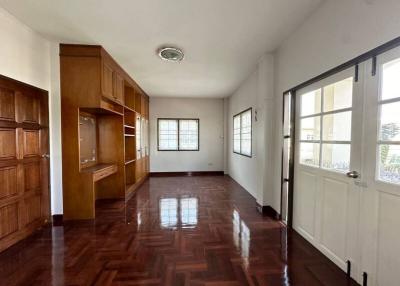 Spacious bedroom with wooden floor and built-in cabinets