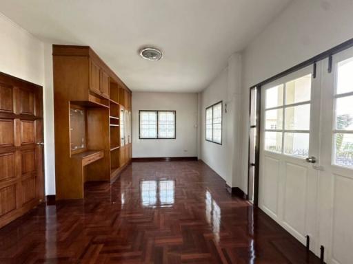 Spacious bedroom with wooden floor and built-in cabinets