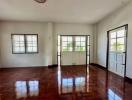 Spacious and bright living room with gleaming hardwood floors and large windows