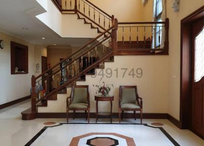 Spacious and elegant entryway with staircase and chandelier
