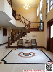 Spacious and elegant entryway with staircase and chandelier