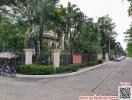 Elegant home exterior with lush greenery and a secure fence