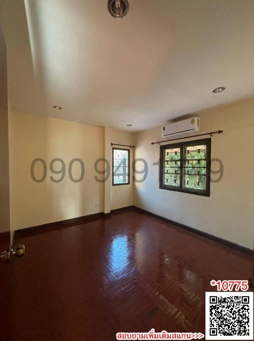 Spacious bedroom with glossy hardwood floors and an air conditioning unit