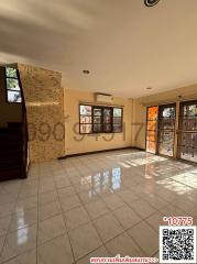 Spacious living room with large windows and tiled flooring