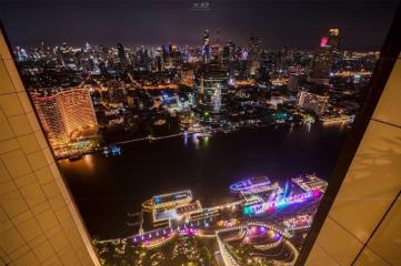 Stunning night view from a high-rise apartment balcony overlooking a vibrant cityscape and river