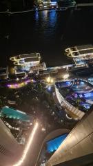 Aerial night view of a vibrant cityscape with illuminated buildings and waterfront