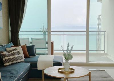 Cozy living room with ocean view and balcony access