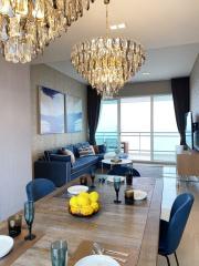 Elegant dining and living room space with ocean view and chandelier