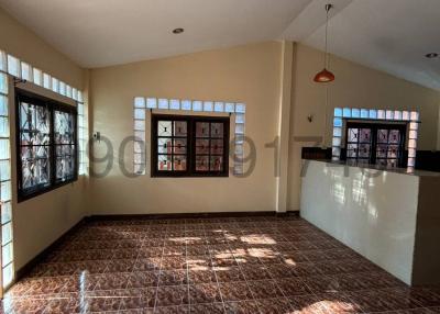 Spacious and well-lit living room with large windows and tiled flooring