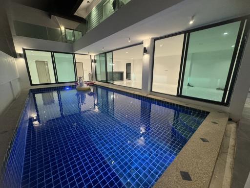 Indoor swimming pool with large windows and modern design