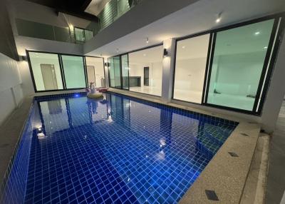 Indoor swimming pool with large windows and modern design