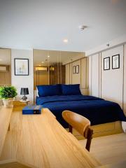 Modern bedroom interior with wooden furniture and blue bedding