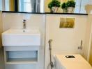 Modern bathroom with clean design featuring a white sink, toilet, and grey tiled flooring