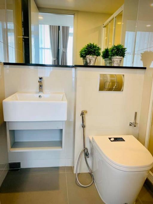 Modern bathroom with clean design featuring a white sink, toilet, and grey tiled flooring