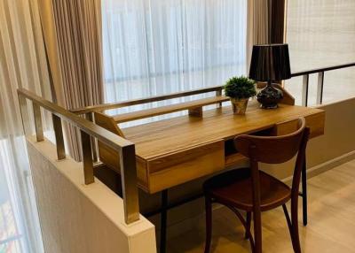 Elegant study area with a wooden desk, chair, and decorative lamp