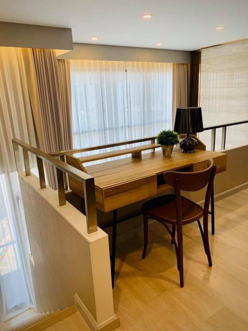 Elegant study area with a wooden desk, chair, and decorative lamp