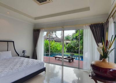 Spacious bedroom with a large bed, glossy tiled flooring, and access to the garden