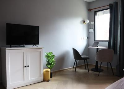 Cozy bedroom with a work area, television, and charming decor