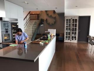 Modern kitchen with stainless steel appliances and a person