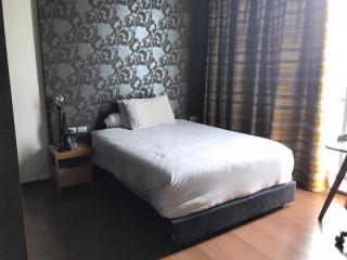 Modern bedroom with stylish wallpaper and hardwood flooring