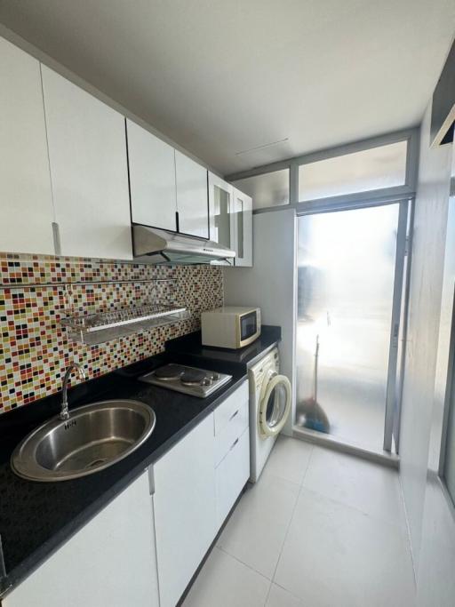 Modern kitchen with white cabinetry and mosaic backsplash