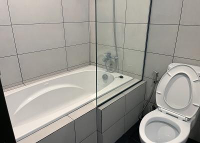 Modern bathroom with white tiles and glass shower partition