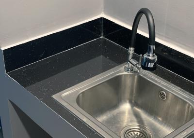 Modern kitchen sink with black granite countertop