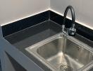Modern kitchen sink with black granite countertop