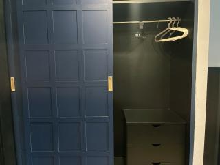 Modern blue closet with hangers and a storage unit