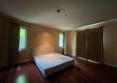 Spacious bedroom with wooden flooring and a large bed