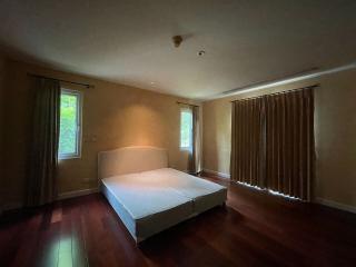 Spacious bedroom with wooden flooring and a large bed