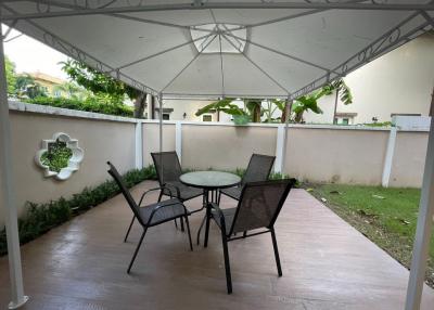 Covered patio with outdoor seating in a residential backyard