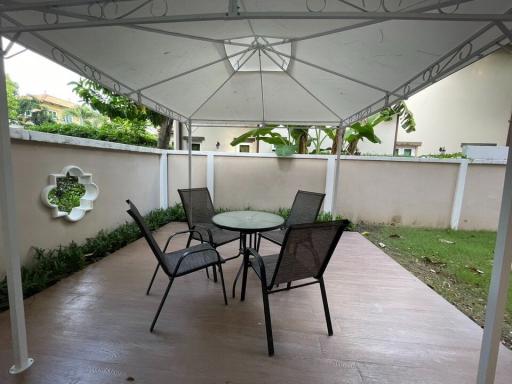 Covered patio with outdoor seating in a residential backyard