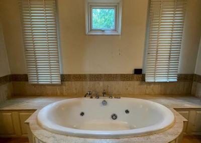 Spacious bathroom with large corner jacuzzi tub and natural light