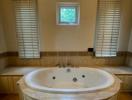 Spacious bathroom with large corner jacuzzi tub and natural light