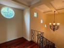 Elegant staircase with hardwood floors and unique round window