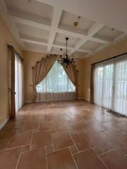 Spacious living room with large windows and coffered ceiling