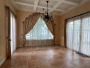 Spacious living room with large windows and coffered ceiling