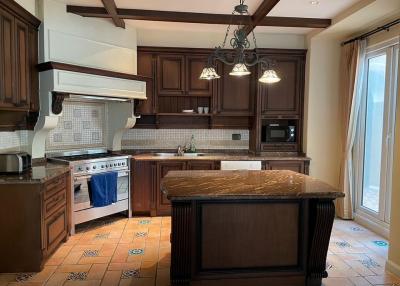 Spacious kitchen with dark wood cabinets and granite countertops