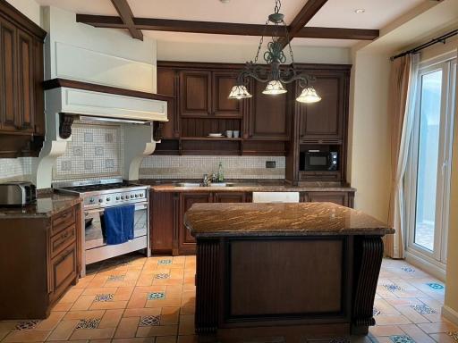 Spacious kitchen with dark wood cabinets and granite countertops