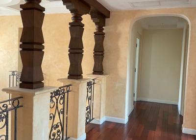 Elegant hallway with hardwood flooring and decorative balusters