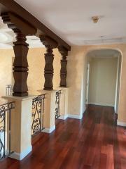 Elegant hallway with hardwood flooring and decorative balusters