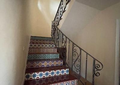 Decorative tiled staircase with elegant wrought iron railing in a home